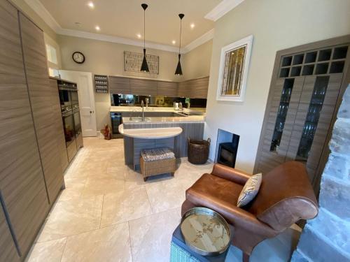 a large living room with a couch and a kitchen at Braid Rd Stunning Villa in Edinburgh