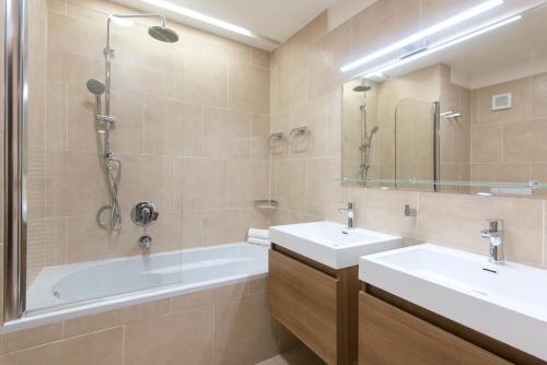 a bathroom with two sinks and a bath tub at Billionaires Club LOFT Sauna City Center in Prague
