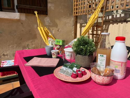 een roze tafel met eten en een fles melk bij Les marches du château - Gîte centre de Nogent-le-Rotrou in Nogent-le-Rotrou