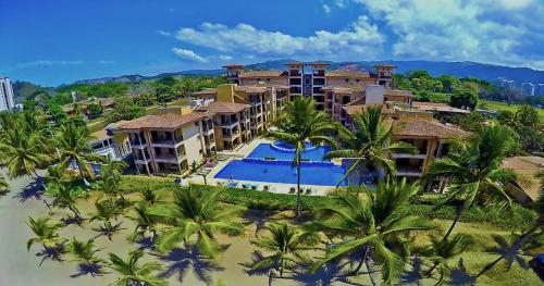 een luchtzicht op een resort met een zwembad en palmbomen bij BEACHFRONT Condo Bahia Encantada Jaco Beach L1 in Jacó