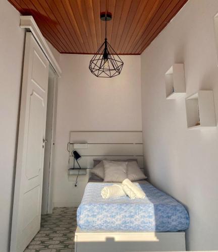 a small bedroom with a bed with a wooden ceiling at The White Sail - Mondello Apartment with Terrace - casa di vincenzo e andrea in Mondello