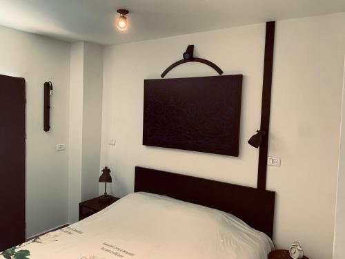 a bedroom with a bed and a picture on the wall at La Guta Studio Loft The Renee Suite in Jerusalem