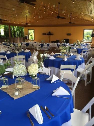 een eetkamer met blauwe tafels en witte stoelen bij The Woodford Inn in Versailles