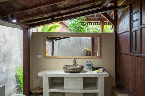 un bagno con lavandino e specchio di The Meranggi ad Ubud