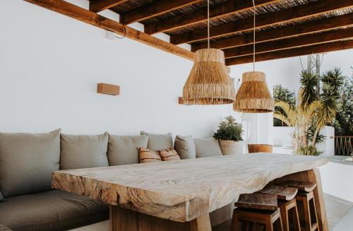 einen großen Holztisch im Wohnzimmer mit Sofa in der Unterkunft Casa Stellar - boutique villa with private heated pool and sea view - sustainably solar powered in San Jose de sa Talaia