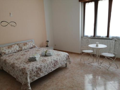 1 dormitorio con 1 cama, mesa y sillas en CASA TRIFO, en Tiggiano