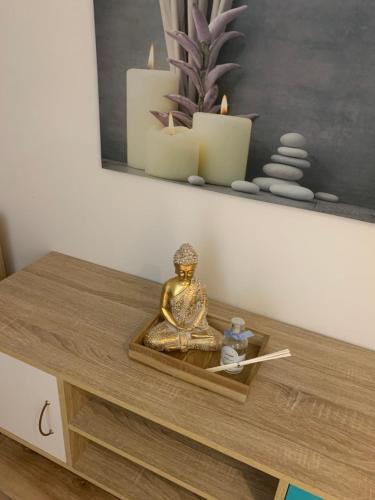 un plateau avec une statue sur une table et des bougies dans l'établissement Chez SOPHIE, logement avec jacuzzi et salle cinéma, à Altviller