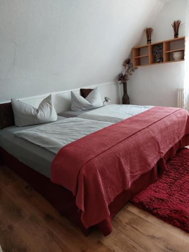 1 dormitorio con 1 cama grande con manta roja en Ferienwohnung Mona Herford, en Herford