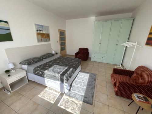 una camera con letto, divano e sedia di [House of Poet] Wide Apartment in the City Center ad Asti