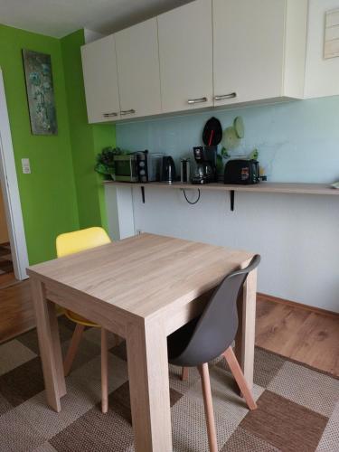 a kitchen with a wooden table and two chairs at Wohnung Mona in Herford