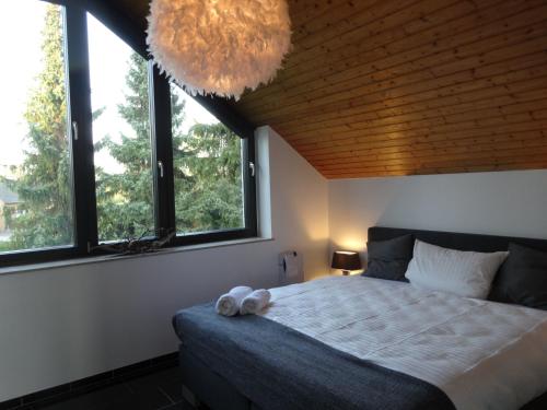 a bedroom with a bed and two windows at Apartment Black & White Neuss in Neuss