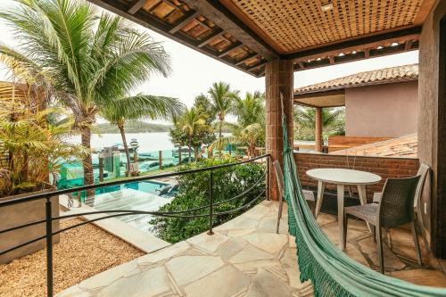 a balcony with a view of a pool and palm trees at Bravo Pousada Design in Cabo Frio