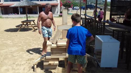 a man and a boy standing next to a pile of wood at Ammos Residence in Minia