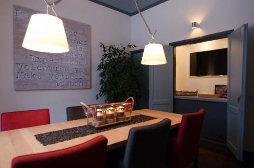 a dining room with a table with chairs and two lights at B&B en SPA Landgoed Matanze in Terwolde