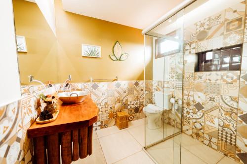 a bathroom with a sink and a shower at Pousada Casa Kuavá Experience in Maragogi