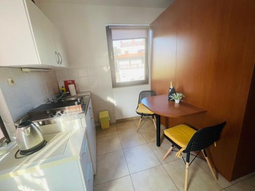 a small kitchen with a table and a small table and chairs at City center studio apartment in Malinska