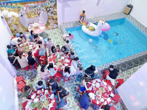 Un groupe de personnes assises autour d'une piscine lors d'une fête dans l'établissement Victory Villa 82 - Gần Biển Bãi Trước, à Vung Tau