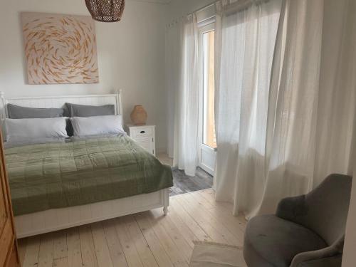 een slaapkamer met een bed, een stoel en een raam bij Relitto Sommerhaus in Borkum