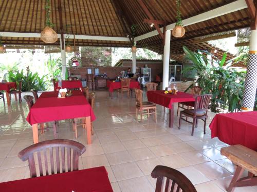 a restaurant with red tables and wooden chairs and tables and chairs at Great Mountain Views Villa Resort in Sidemen