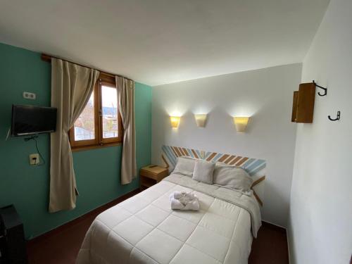 um quarto com uma cama com um urso de peluche em MAKTUB HOSTERIA em El Bolsón