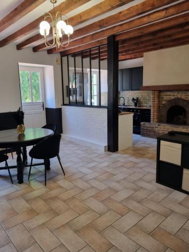 Il dispose d'une cuisine et d'un salon avec une table et une cheminée. dans l'établissement Longère indépendante avec terrain de tennis privé, à Saint-Maugan