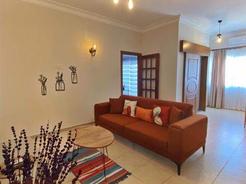 a living room with a brown couch and a table at Lavender Homes, Walled City in Famagusta