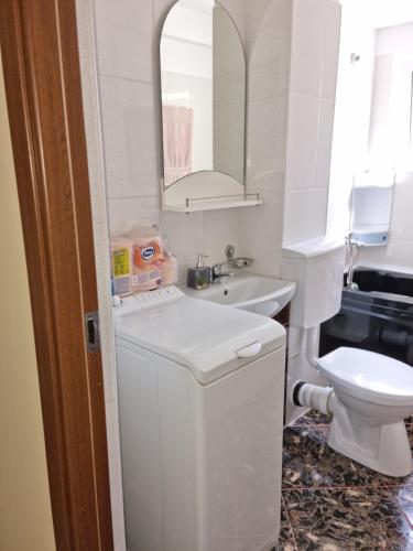 Baño blanco con lavabo y aseo en Apartament Mia, en Ocnele Mari