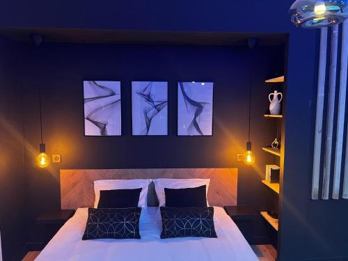 a bedroom with a bed with four pictures on the wall at CK Suite & Spa Reims in Reims
