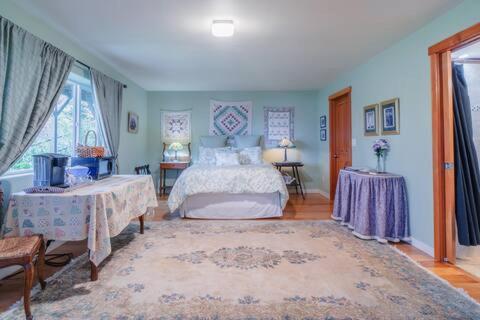 阿納科特斯的住宿－Sunrise Suite on the Sound，一间大卧室,配有一张床和两张桌子