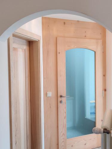 ein Torbogen zu einem Zimmer mit einer Holztür in der Unterkunft Eguia in Wolkenstein in Gröden