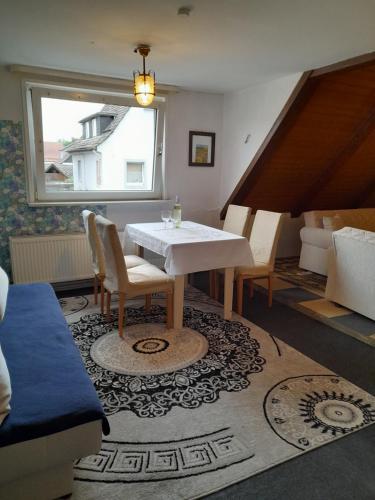 sala de estar con mesa, sillas y sofá en Ferienwohnung Why Not en Polle