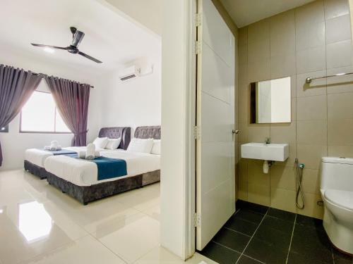ein Schlafzimmer mit einem Bett und ein Badezimmer mit einem Waschbecken in der Unterkunft Tamu Place 3-Bedroom Serviced Apartment with Pool in Kuala Terengganu