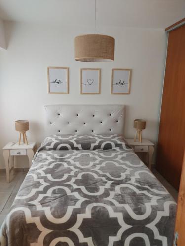 a bedroom with a bed with a black and white blanket at Dpto de 1 dormitorio en el centro de la ciudad in Rosario