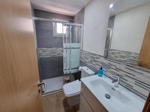 a bathroom with a sink and a toilet and a mirror at Loft Blanco in L'Ametlla de Mar