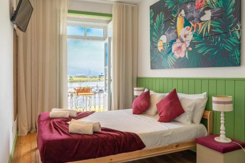 1 dormitorio con 1 cama grande y ventana en Naval Guest House & Bistrô en Vila do Conde