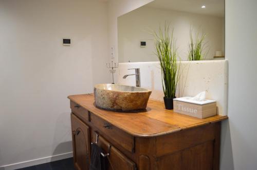 a bathroom with a sink on top of a wooden dresser at Grande Chambre d'hôte Les Chats-Pîtres in La Rochette