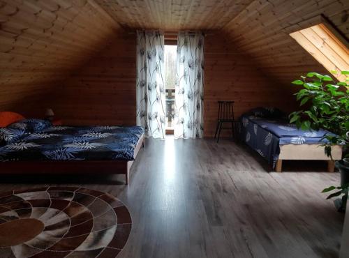 a attic bedroom with two beds and a window at Väike-Puusmetsa puhkemaja in Valtina