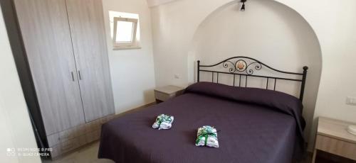 een slaapkamer met een bed met twee schoenen erop bij Baciati dal Sole in Martina Franca