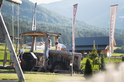a group of people standing on a playground at Aparthotel Familiaris - Family Apartments - Pools & Spa in Dolomites in Valdaora