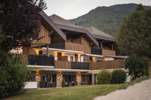 a large building with a mountain in the background at Aparthotel Familiaris - Family Apartments - Pools & Spa in Dolomites in Valdaora