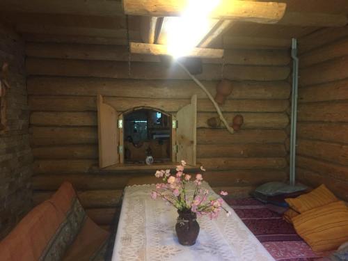 a room with a table with a vase of flowers on it at Oselia Lada in Tukhlya