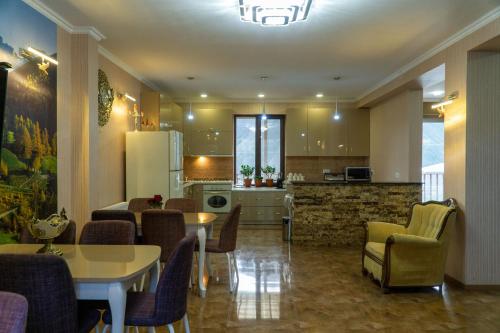 a kitchen and living room with a table and chairs at Hotel Diamond Kazbegi in Stepantsminda