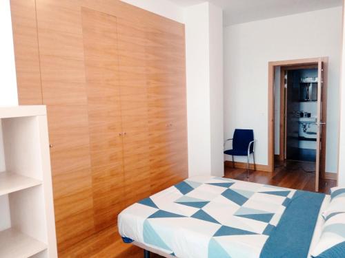 um quarto com uma cama e uma parede de madeira em RiverSide em Barakaldo