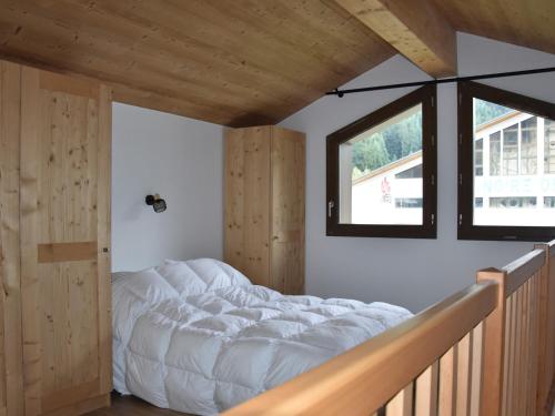 un lit dans une chambre avec une fenêtre dans l'établissement Appartement moderne à Pralognan-la-Vanoise, proche des loisirs, balcon et garage inclus - FR-1-464-209, à Pralognan-la-Vanoise
