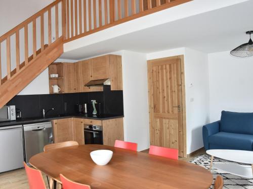 une cuisine et une salle à manger avec une table et une chaise bleue dans l'établissement Appartement moderne à Pralognan-la-Vanoise, proche des loisirs, balcon et garage inclus - FR-1-464-209, à Pralognan-la-Vanoise