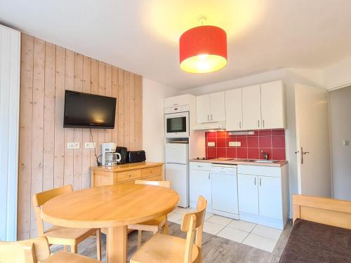 une cuisine avec une table en bois et une salle à manger dans l'établissement Appartement Lumineux à Flaine Forêt, Proche Pistes avec Balcon et Parking Couvert - FR-1-425-177, à Flaine