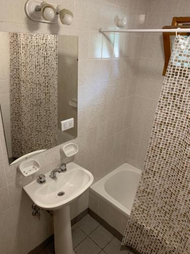 un bagno con lavandino, doccia e vasca di CABAÑAS AILIN-CO a El Bolsón