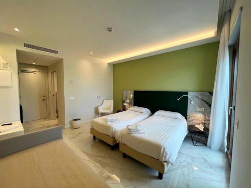 a bedroom with a large bed and a green wall at Hotel Alpha in Sant'Agnello