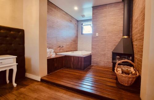 a bathroom with a bath tub and a fireplace at Pousada Quinta do Vale in Gramado