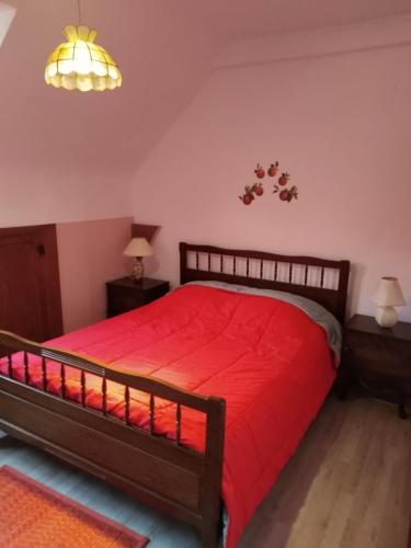 um quarto com uma cama vermelha e duas mesas de cabeceira em Appart du 119 em Sainte-Croix-aux-Mines